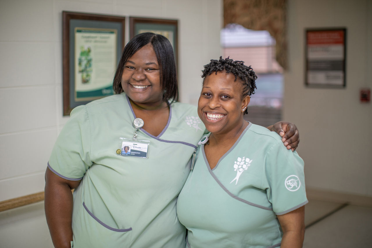 Two CNAs standing in the hallway of a skilled nursing center